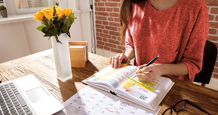 Woman writing on a calendar